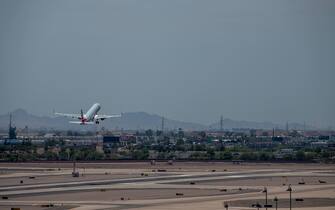 A plane takes off from Phoenix Sky Harbor International Airport (PHX) during a heatwave in Phoenix, Arizona, US, on Tuesday, July 11, 2023. A massive heat wave will build in the southern US and expand into the Pacific Northwest this week, with temperatures in the Southwest rising to as much as 120F (49C) on Thursday, Friday and Saturday. Photographer: Ash Ponders/Bloomberg via Getty Images