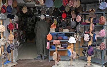 A customer shops for caps at a store ahead of the Eid al-Fitr, which marks the end of the holy month of Ramadan, in Srinagar on April 17, 2023. (Photo by Tauseef MUSTAFA / AFP) (Photo by TAUSEEF MUSTAFA/AFP via Getty Images)