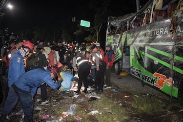 Officers check the debris and belongings of passengers after a bus crash that killed 11 people, according to local police, in Subang, West Java, on May 11, 2024. (Photo by Timur MATAHARI / AFP) (Photo by TIMUR MATAHARI/AFP via Getty Images)