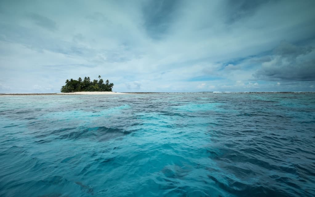 FUNAFUTI, TUVALU - NOVEMBER 26: An islet is viewed in the Funafuti atoll on November 26, 2019 in Funafuti, Tuvalu. The low-lying South Pacific island nation of about 11,000 people has been classified as ‘extremely vulnerable’ to climate change by the United Nations Development Programme. The world’s fourth-smallest country is struggling to cope with climate change related impacts including five millimeter per year sea level rise (above the global average), tidal and wave driven flooding, storm surges, rising temperatures, saltwater intrusion and coastal erosion on its nine coral atolls and islands, the highest of which rises about 15 feet above sea level. In addition, the severity of cyclones and droughts in the Pacific Island region are forecast to increase due to global warming. Some scientists have predicted that Tuvalu could become inundated and uninhabitable in 50 to 100 years or less if sea level rise continues. The country is working toward a goal of 100 percent renewable power generation by 2025 in an effort to curb pollution and set an example for larger nations. Tuvalu is also exploring a plan to build an artificial island.  (Photo by Mario Tama/Getty Images)