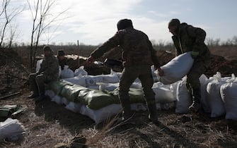 Ukrainian servicemen pile up earthbags to build a fortification not far from town of Avdiivka in the Donetsk region, amid the Russian invasion of Ukraine, on February 17, 2024. (Photo by Anatolii STEPANOV / AFP)