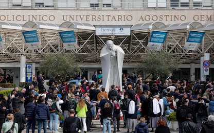 People under the statue of late Pope John Paul II outside Agostino Gemelli Hospital. Pope Francis will be discharged today with prescription for two months of rest after spending more than five weeks in the hospital or a bilateral pneumonia, Italy, 23 March 2025. ANSA/GIUSEPPE LAMI