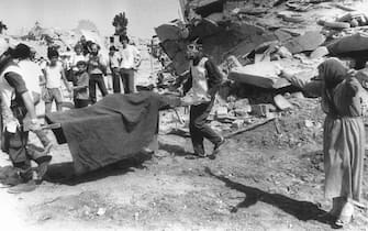A Palestinian woman cries while civil defense workers carry the body of one of her relatives away from the rubble of her home in the Palestinian refugee camp of Sabra, in West Beirut 19 September 1982. Hundreds of Palestinians were killed in Sabra and Shatila, the two biggest camps in Lebanon.        (Photo credit should read STF/AFP via Getty Images)