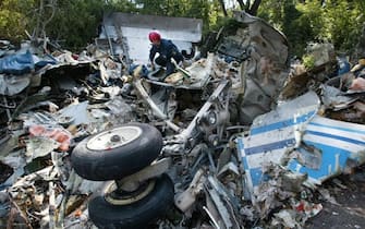 RUSSIA: AEREI, RIBELLI CECENI AMMETTONO IPOTESI DIROTTAMENTO MA NEMICI LINEA PUTIN SONO MOLTI, SCRIVONO SU LORO SITO Emergency Ministry servicemen climbs trough the debris of the TU-154 airplane, which crashed near the village of Gluboky in Rostov-on-Don region, Thursday 26 August 2004. Two aircrafts - TU-154 and TU-134, which left Domodedovo airport late Tuesday, had crashed virtually at the same time in Rostov-on-Don region and in Tula region. 89 people died in these two crashes.  ANSA /ANATOLY MALTSEV /JI