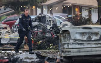 Investigators look through the site where a small plane crashed into a San Diego, California, residential street on May 22, 2025. The Federal Aviation Authority said a Cessna 550 crashed at around 3:45 am local time. The neighborhood is close to the Montgomery-Gibbs Executive Airport. The crash left a "gigantic debris field" and damaged some 15 homes and parked cars, ABC News quoted the San Diego assistant fire chief as saying. (Photo by Sandy Huffaker / AFP)