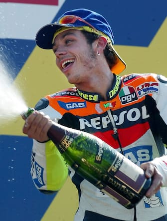 PEN06 - 20020714 - DONINGTON, UNITED KINGDOM : Valentino Rossi of Italy sprays champagne after winning the British Motor Cycle Grand Prix 14 July 2002, at Donington Park. Max Biaggi of Italy was second and Alex Barros of Brazil third.  EPA PHOTO EPA/GERRY PENNY