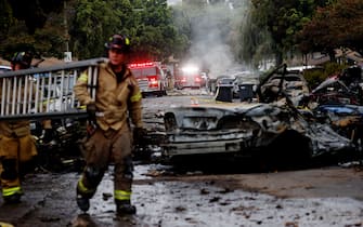 Firefighters work the site where a small plane crashed into a San Diego, California, residential street on May 22, 2025. The Federal Aviation Authority said a Cessna 550 crashed at around 3:45 am local time. The neighborhood is close to the Montgomery-Gibbs Executive Airport. The crash left a "gigantic debris field" and damaged some 15 homes and parked cars, ABC News quoted the San Diego assistant fire chief as saying. (Photo by Sandy Huffaker / AFP)