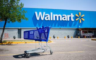 Mendoza, Argentina - January, 2020: Shopping cart on a parking lot in front of main entrance to Walmart supermarket outdoor on the street with no peop