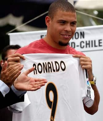 Real Madrid's Brazilian player Ronaldo donates his soccer t-shirt for children while visiting a Chilean soccer school on Monday, 22 December 2003, in Santiago. Ronaldo is in Chile where he will play in a farewell match tonight for Chilean soccer star Ivan Zamorano at the National Stadium.  EPA/Iván Alvarado  