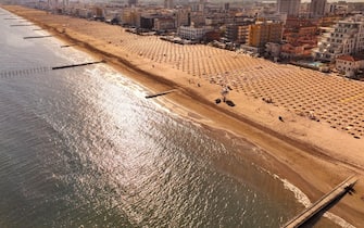 Spiaggia dorata di Jesolo con lettini e ombrelloni in località estiva di mare vista dall'alto durante la giornata di sole