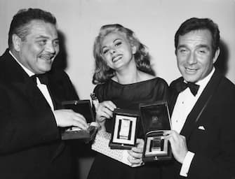 From left to right, actors Folco Lulli, Sandra Milo and Ugo Tognazzi receive Nastri d'Argento (Silver Ribbons) at the Italian National Syndicate of Film Journalists awards in Rome, Italy, 6th April 1964. Lulli and Milo received Best Supporting Actor and Actress respectively, and Tognazzi won Best Actor.  (Photo by Keystone/Hulton Archive/Getty Images)
