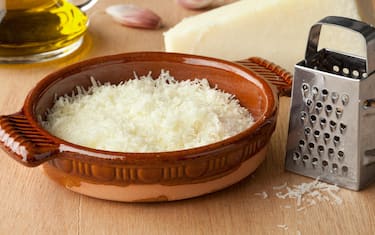 Bowl with grated Italian pecorino romano cheese, olive oil and garlic