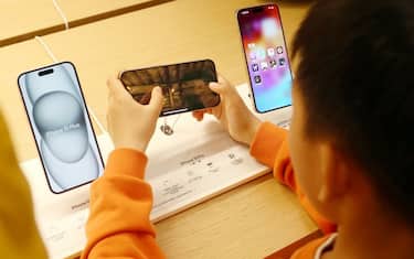 SHANGHAI, CHINA - MARCH 23, 2024 - A child tries an e-sports game for the iPhone 15 series smartphone at Apple's flagship store in Shanghai, China, March 23, 2024. (Photo credit should read CFOTO/Future Publishing via Getty Images)