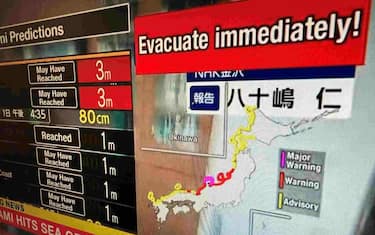 This image taken in Hong Kong on January 1, 2024 shows a warning message on a screen from a live feed on NHK World asking people to evacuate from the area after a series of major earthquakes hit central Japan. A powerful 7.5 earthquake hit central Japan on January 1, the USGS said, prompting tsunami warnings and authorities to urge people in the area to move to higher ground. (Photo by Mladen ANTONOV / AFP)