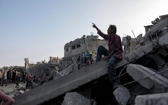 epa10959092 A Palestinian man sits over the rubble of a residential building following an airstrike at the Maghazi refugee camp in the central Gaza Strip, 05 November 2023. More than 9,400 Palestinians and at least 1,400 Israelis have been killed, according to the IDF and the Palestinian health authority, since Hamas militants launched an attack against Israel from the Gaza Strip on 07 October, and the Israeli operations in Gaza and the West Bank which followed it.  EPA/HAITHAM IMAD