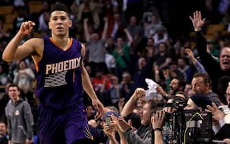 BOSTON - MARCH 24: An off-balance three pointer by Phoenix Suns guard Devin Booker (1) brings the Garden fans to their feet and Booker signals it's good for 3 of his 70 points on the night. The Boston Celtics host the Phoenix Suns at TD Garden in Boston on Mar. 24, 2017. (Photo by Barry Chin/The Boston Globe via Getty Images)