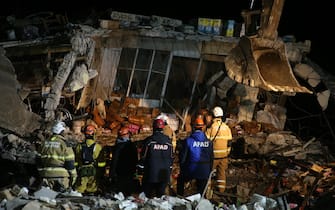 HATAY, TURKIYE - FEBRUARY 21: Personnel and Brazilian search and rescue team removes the debris of a building that collapsed in Antakya district of Hatay following 6.4 and 5.8 magnitude earthquakes hit the Hatay province of Turkiye on February 21, 2023. Firefighters responded to the fire, which broke out under the rubble as a result of the collapse of the building. Two earthquakes jolted Turkiye's southernmost Hatay province on Monday, just two weeks after major quakes hit the region. According to the Disaster and Emergency Management Presidency (AFAD), one of the quakes took place at around 20.04 p.m. local time (1704GMT) in the Defne district of Hatay, with a magnitude of 6.4, while the other took place three minutes later, with the epicenter in Hatay's Samandag province, with a magnitude of 5.8. Several countries in the region, including Lebanon, also felt the tremors. (Photo by Tahir Turan Eroglu/Anadolu Agency via Getty Images)