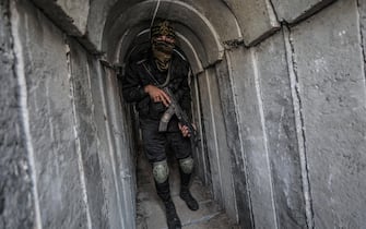 epa09955933 A Palestinian fighter of Al-Quds brigades, the military wing of Palestinian Islamic Jihad (PIJ), takes position in a military tunnel near the rally marking the first anniversary of the May 2021 conflict between Israel and Gaza, in Beit Hanun, northern Gaza Strip, 18 May 2022.  EPA/MOHAMMED SABER