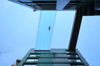 A man swims in the Sky Pool, a transparent swimming pool bridge across two exclusive residential blocks standing next to the US Embassy in Nine Elms, south London, the first of its kind in the world. Picture date: Friday April 23, 2021. (Photo by Victoria Jones/PA Images via Getty Images)