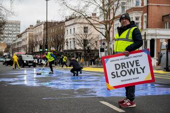 LONDON, ENGLAND - FEBRUARY 23: In this handout provided by Led By Donkeys, Activists from political campaign group Led By Donkeys, pour paint onto the road to create a giant Ukrainian flag outside the Russian Embassy on February 23, 2023 in London, England. The group created the flag using washable paint poured onto the road and then driven through by passing vehicles to show solidarity with Ukraine on the eve of the one year mark since the Russian invasion of Ukraine began. (Photo by Handout/Led By Donkeys via Getty Images)