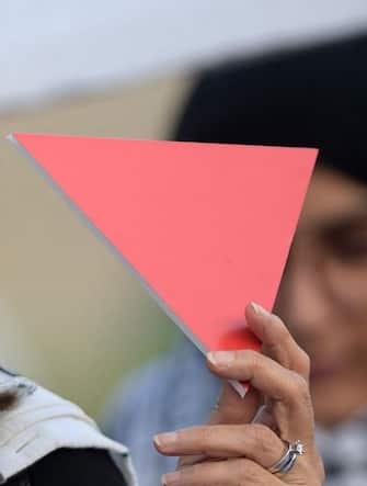 A protester holds an inverted "red triangle", a symbol that the Palestinian Hamas movement's military wing Al-Qassam Brigades uses to identify Israeli targets in their videos, during a solidarity sit-in with the Gaza Strip, in Manama on November 17, 2023, amid ongoing battles between Israel and Hamas militants. (Photo by Mazen Mahdi / AFP) (Photo by MAZEN MAHDI/AFP via Getty Images)