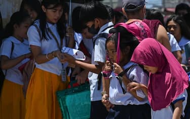 A student uses a bag to protect herself from the sun during a hot day in Manila on April 2, 2024. More than a hundred schools in the Philippine capital shut their classrooms on April 2, as the tropical heat hit "danger" levels, education officials said. (Photo by JAM STA ROSA / AFP) (Photo by JAM STA ROSA/AFP via Getty Images)