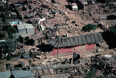 Houses lay in ruins and rubble in a Guatemala City neighborhood after an earthquake.