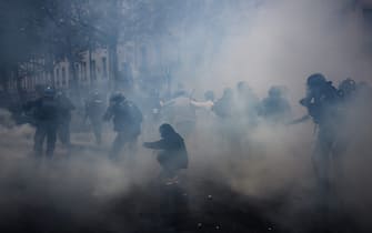 A protester (C) protects himself as French CRS riot police charge during a demonstration on May Day (Labour Day) to mark the international day of the workers, more than a month after the government pushed an unpopular pensions reform act through parliament, in Lyon, eastern France, on May 1, 2023. - Opposition parties and trade unions have urged protesters to maintain their three-month campaign against the law that will hike the retirement age to 64 from 62. (Photo by JEFF PACHOUD / AFP) (Photo by JEFF PACHOUD/AFP via Getty Images)