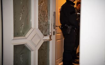 23 November 2021, North Rhine-Westphalia, GÃ¼tersloh: Police officers stand next to the destroyed door of a house they searched. Police have arrested several suspects in simultaneous raids in several countries against so-called "tarpaulin slashers". It is said to be about gangs of thieves who steal loads from trucks. Photo: Lino Mirgeler/dpa (Photo by Lino Mirgeler/picture alliance via Getty Images)