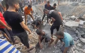 This image grab taken from AFPTV video footage shows Palestinians looking for survivors in a crater following a stike on a refugee camp in Jabalia on the northern Gaza Strip, on October 31, 2023, amid relentless Israeli bombardment of the Palestinian territory. The health ministry in the Hamas-run Gaza Strip said at least 50 people were killed on October 31 in Israeli bombardment of the refugee camp in the Palestinian territory. (Photo by Fadi Alwhidi / AFP) / "The erroneous mention[s] appearing in the metadata of this photo by Fadi Alwhidi has been modified in AFP systems in the following manner: [northern Gaza] instead of [southern Gaza]. Please immediately remove the erroneous mention[s] from all your online services and delete it (them) from your servers. If you have been authorized by AFP to distribute it (them) to third parties, please ensure that the same actions are carried out by them. Failure to promptly comply with these instructions will entail liability on your part for any continued or post notification usage. Therefore we thank you very much for all your attention and prompt action. We are sorry for the inconvenience this notification may cause and remain at your disposal for any further information you may require." (Photo by FADI ALWHIDI/AFP via Getty Images)