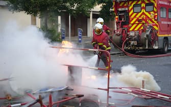 Firefighters work to put out a fire in the street after a demonstration in Nanterre, west of Paris, on June 27, 2023, after French police killed a teenager who refused to stop for a traffic check in the city. The 17-year-old was in the Paris suburb early on June 27 when police shot him dead after he broke road rules and failed to stop, prosecutors said. The event has prompted expressions of shock and questions over the readiness of security forces to pull the trigger. (Photo by Zakaria ABDELKAFI / AFP) (Photo by ZAKARIA ABDELKAFI/AFP via Getty Images)