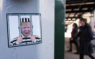 epa10556346 A sticker with the face of former President Donald J. Trump is displayed in front of New York Criminal Court in New York, New York, USA, 02 April 2023. A Manhattan grand jury voted to indict former President Donald J. Trump last week and he is reportedly planning to turn himself in at the courthouse and appear before a judge to hear the charges against him on 04 April.  EPA/JUSTIN LANE
