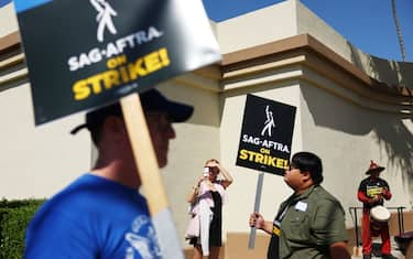 LOS ANGELES, CALIFORNIA - OCTOBER 02: A person takes photos as striking SAG-AFTRA members picket with WGA (Writers Guild of America) members marching in solidarity outside Paramount Studios on October 02, 2023 in Los Angeles, California. Contract negotiations between SAG-AGTRA and the Alliance of Motion Picture and Television Producers (AMPTP) were expected to take place today in the first formal discussions since the actors went on strike in July. (Photo by Mario Tama/Getty Images)