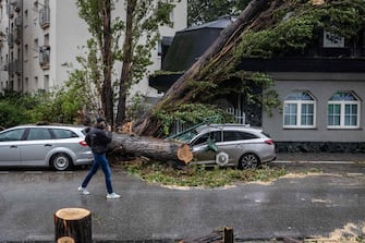 A destroyed car is seen under a tree that fell due to strong winds at the Ru inov estate in Bratislava, Slovakia, on September 15, 2024. One person has drowned in Poland and an Austrian fireman has died responding to floods, authorities said, as Storm Boris lashed central and eastern Europe with torrential rains. Since Thursday, September 12, 2024, swathes of Austria, the Czech Republic, Hungary, Romania and Slovakia have been hit by high winds and unusually fierce rainfall. The storm had already caused the death of five people in Romania, and thousands have been evacuated from their homes across the continent. (Photo by TOMAS BENEDIKOVIC / AFP)