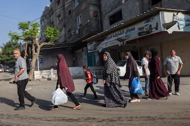 TOPSHOT - Palestinians carrying their belongings flee to safer areas in Gaza City after Israeli air strikes, on October 13, 2023. Israel has called for the immediate relocation of 1.1 million people in Gaza amid its massive bombardment in retaliation for Hamas's attacks, with the United Nations warning of "devastating" consequences. (Photo by MOHAMMED ABED / AFP) (Photo by MOHAMMED ABED/AFP via Getty Images)