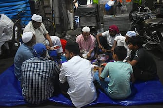 Muslims are eating their Iftar (breaking of fast) meal beside the street in Kolkata, India, on April 7, 2024. (Photo by Sudipta Das/NurPhoto via Getty Images)