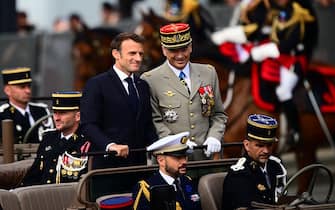French President Emmanuel Macron (L) and France's Chief of the Defence Staff Thierry Burkhard parade in the command car during the Bastille Day military parade on the Champs-Elysees avenue in Paris on July 14, 2023. (Photo by Emmanuel DUNAND / AFP) (Photo by EMMANUEL DUNAND/AFP via Getty Images)