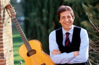 The Italian singer-songwriter and actor Giorgio Gaber (Giorgio Gaberscik) posing smiling with his guitar. 1982 (Photo by Angelo Deligio/Mondadori via Getty Images)