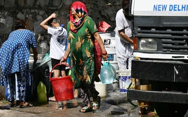 Residents fill containers with water supplied by a municipal tanker in New Delhi on May 30, 2024, amid ongoing heatwave. India is enduring a crushing heatwave with temperatures in several cities sizzling well above 45 degrees Celsius (104 degrees Fahrenheit). (Photo by Money SHARMA / AFP) (Photo by MONEY SHARMA/AFP via Getty Images)