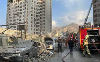 epa12172720 Fire fighters work outside a building that was hit by Israeli air strikes north of Tehran, Iran, 13 June 2025. Israel confirms it has launched strikes on Iran's 'nuclear program' as blasts are heard across the country. The strikes are part of Operation Rising Lion, Israel's Prime Minister Benjamin Netanyahu said, adding Iran was a threat to "Israel's very survival".  EPA/ABEDIN TAHERKENAREH