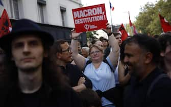 epa11591121 People attend a protest rally in Paris, France, 07 September 2024 as the French left parties called for rallies against President Macron's politics. Protests are taking place across France over the appointment of Michel Barnier as the new French prime minister, after the election that resulted in a National Assembly without a majority and in which the left won the largest number of seats. The poster reads "Macron destitution''.  EPA/YOAN VALAT