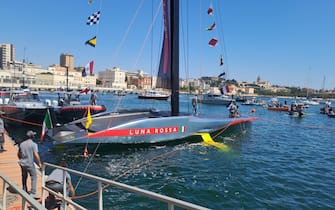 Varata la nuova Ac75 di Luna Rossa a Cagliari, 13 aprile 2024. Con la benedizione del vescovo Giuseppe Baturi è scattato alle 13.23 il via alla nuova avventura della barca che cercherà di portare in Italia la Coppa America. La madrina dell'inaugurazione è stata come al solito Miuccia Prada accompagnata dal patron Patrizio Bertelli. Poi la fatidica frase 'Io ti battezzo Luna Rossa'. Con la bottiglia di spumante che si è schiantata sulla scocca argentata della nuova barca dai colori argento, grigio e rosso con due ali gialle che la faranno "volare" sull'acqua. Uno scafo molto affusolato per affrontare meglio le onde. ANSA/ ROBERTA CELOT