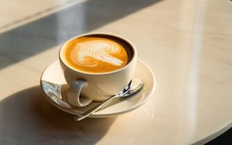 Feshly brewed  latte coffee on a white table, a coffee drink made with espresso and steamed milk.