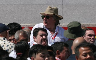 TOPSHOT - French actor Gerard Depardieu (C) looks on as he attends a military parade with an entourage including French writer Yann Moix (R) and mass rally on Kim Il Sung square in Pyongyang on September 9, 2018. - North Korea was marking the 70th anniversary of its founding.Korean People's Army (KPA) tanks take part in a military parade on Kim Il Sung square in Pyongyang on September 9, 2018. (Photo by Sebastien BERGER / AFP)        (Photo credit should read SEBASTIEN BERGER/AFP via Getty Images)