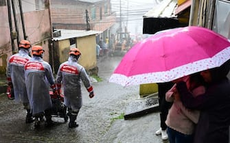 Firefighters move an electric generator after completing their rescue work at a zone affected by heavy rains in Petropolis, Brazil on March 23, 2024. At least nine people died in the midst of a strong storm that hits the southeast of Brazil, particularly the mountain area of the state of Rio de Janeiro, where authorities deployed a strong operation this Saturday in the face of a "critical" situation. The authorities reported three deaths in the collapse of a house in the city of Petropolis, about 70 kilometers from the capital of Rio, in a bulletin issued by an emergency committee formed by the government of Rio together with the Fire and Defense forces. (Photo by Pablo PORCIUNCULA / AFP) (Photo by PABLO PORCIUNCULA/AFP via Getty Images)