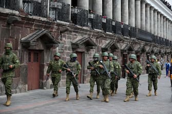 epa11066484 Soldiers patrol a street in Quito, Ecuador, 09 January 2024. The president of Ecuador, Daniel Noboa, decreed a state of emergency due to the acts of violence in the country, which allows the Armed Forces to support the police in security tasks.  EPA/Jose Jacome