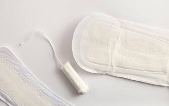 Background with female absorbent protectors for the menstrual cycle. Pantiliner and tampon on white background. Top view. Horizontal composition.