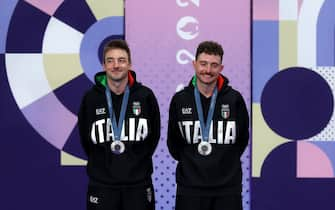 PARIS, FRANCE - AUGUST Silver medalists Elia Viviani and Simone Consonni of Team Italy celebrate on the podium after the Men's Madison Final on day fifteen of the Olympic Games Paris 2024 at Saint-Quentin-en-Yvelines Velodrome on August 10, 2024 in Paris, France. (Photo by Tim de Waele/Getty Images)