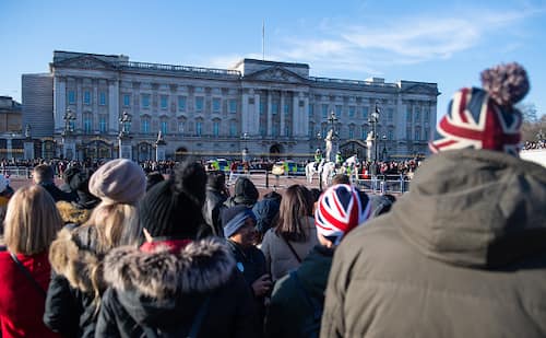 Crowds watch the changing of the guard ceremony outside Buckingham Palace, London, following a statement by Queen Elizabeth II and Buckingham Palace that the Duke and Duchess of Sussex have concluded talks over stepping back from their royal roles. (Photo by Dominic Lipinski/PA Images via Getty Images)