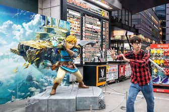 This picture taken on May 7, 2023 shows a visitor posing next to a statue of a character from Japanese gaming giant Nintendo's video game "The Legend of Zelda: Tears of the Kingdom" on display at a store in the Akihabara district of Tokyo. - Nintendo, who will report net annual earnings later on May 9, will also release the latest instalment in its long-running "Legend of Zelda" game series, titled "Tears of the Kingdom", for the Switch on May 12. (Photo by Philip FONG / AFP) (Photo by PHILIP FONG/AFP via Getty Images)